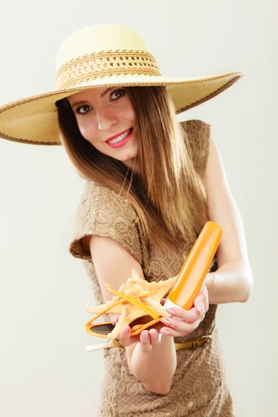 Woman holds sunglasses and sunscreen lotion — Stock Photo, Image