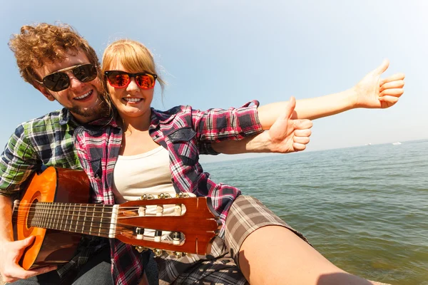 Jovem hipster com guitarra e mulher . — Fotografia de Stock