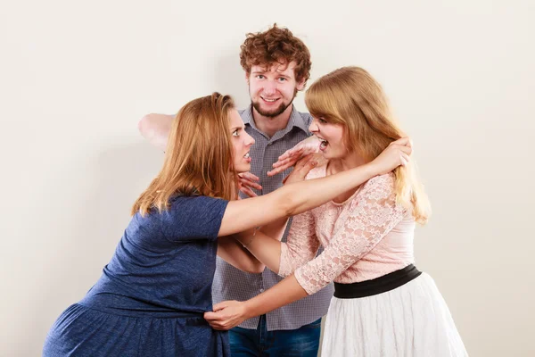 Aggressive wütende Frauen streiten um Mann. — Stockfoto