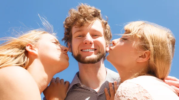 Due ragazze baciare un ragazzo divertirsi all'aperto — Foto Stock