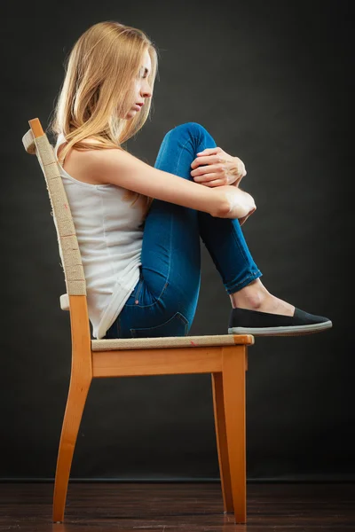Νεαρή γυναίκα λυπημένος που κάθεται στην καρέκλα — Φωτογραφία Αρχείου