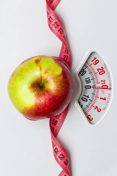 Apple with measuring tape on weight scale. Dieting — Stock Photo, Image