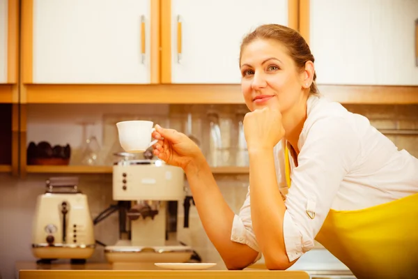 Volwassen vrouw met kopje koffie in keuken. — Stockfoto