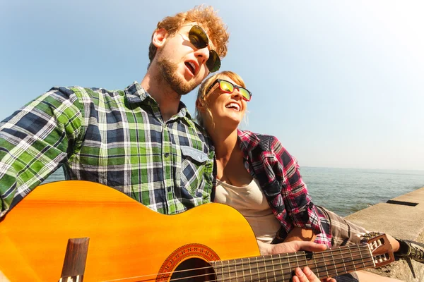 Giovane hipster suonare la chitarra per la donna . — Foto Stock