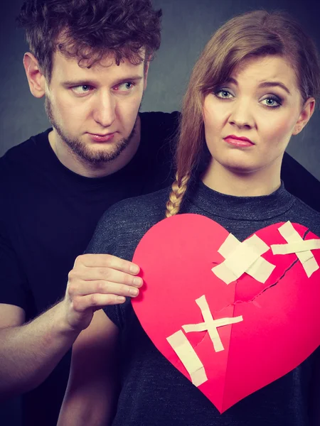 Triste pareja sostiene corazón roto . — Foto de Stock