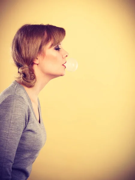 Blondes Mädchen kaut Kaugummi und macht Luftballon. — Stockfoto