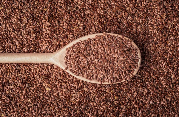 Σπόρους λιναριού λιναρόσπορου σχετικά με ξύλινο κουτάλι — Φωτογραφία Αρχείου