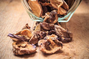 Ahşap masa üzerinde kavanoza kuru mantar.