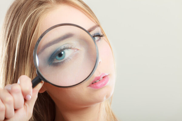 girl holding on eye magnifying glass loupe