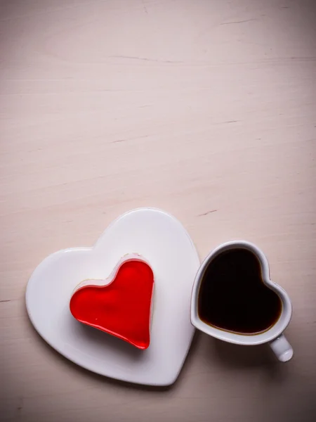 Heart shaped coffee cup and cake on wood surface — Stock Photo, Image