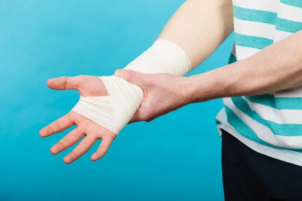 Man with painful bandaged hand. — Stock Photo, Image