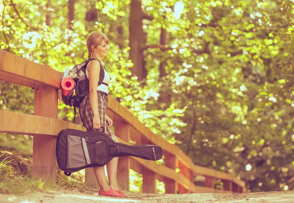 Mulher com mochila e guitarra — Fotografia de Stock