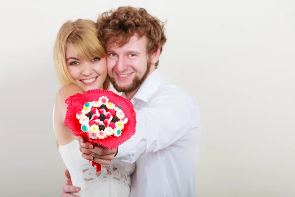 Gelukkige paar met snoep bos bloemen. Liefde. — Stockfoto