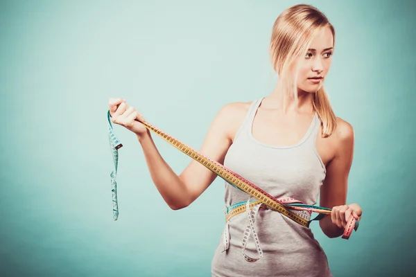 Chica fitness midiendo su cuerpo con cintas —  Fotos de Stock