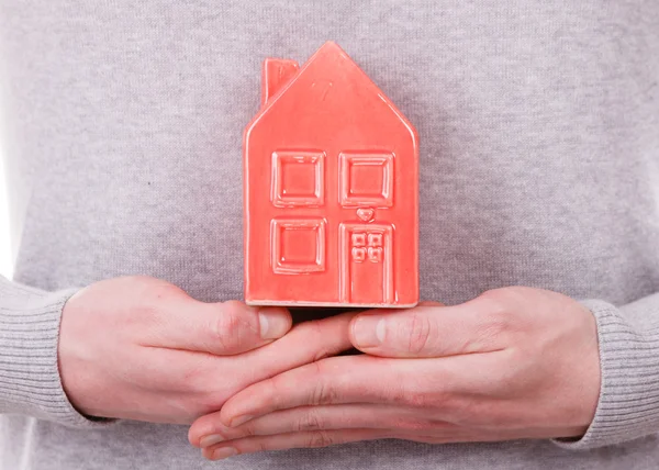 Person holding house model.