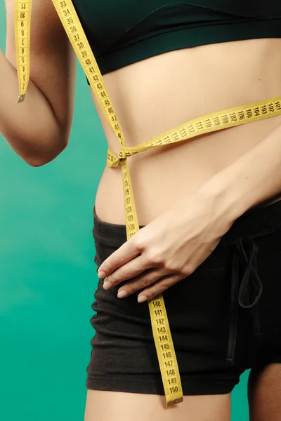 Fitness girl measuring her waistline — Stock Photo, Image