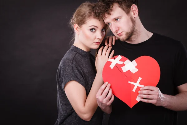 Triste pareja sostiene corazón roto — Foto de Stock