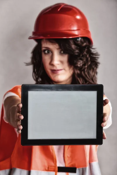 Chica en casco de seguridad mostrando el comprimido — Foto de Stock