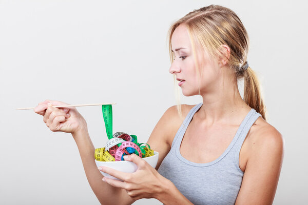 Girl with measuring tapes in bowl