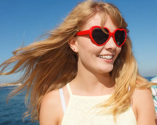 Fille en lunettes de soleil rouges se détendre sur la côte de la mer . — Photo