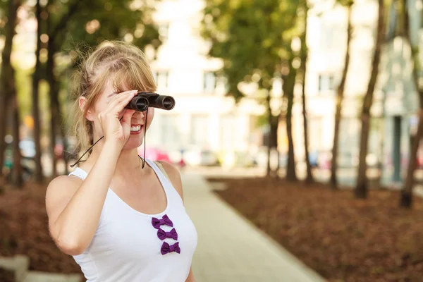 Frau blickt durch Fernglas in die Stadt — Stockfoto