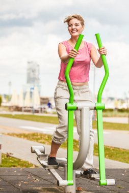 Aktif kadın üzerinde eliptik eğitmen egzersiz.