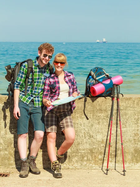 Pareja mochilero con mapa por playa — Foto de Stock