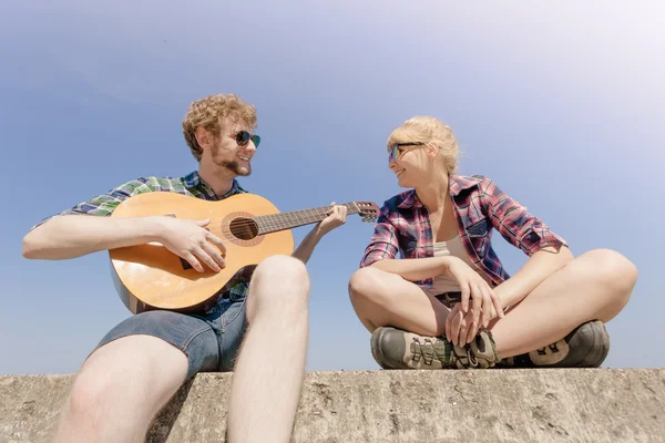 Młody człowiek hipster gry na gitarze dla kobiety. — Zdjęcie stockowe