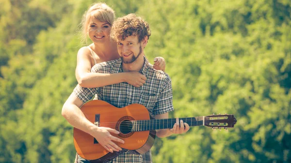 Giovane coppia campeggio suonare la chitarra all'aperto — Foto Stock