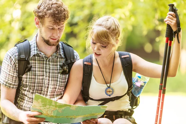 Excursionistas mochileros pareja lectura mapa en viaje . — Foto de Stock
