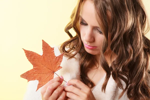 Pretty autumnal girl with maple leaf in hand — Stock Photo, Image