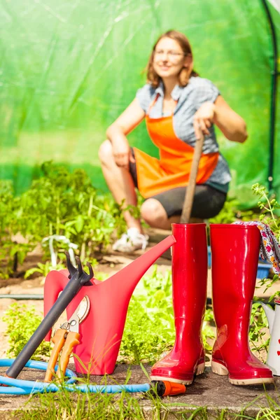 Perempuan petani dan alat berkebun di kebun — Stok Foto