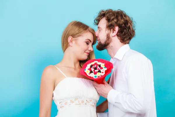 Loving couple with candy bunch flowers. Love.