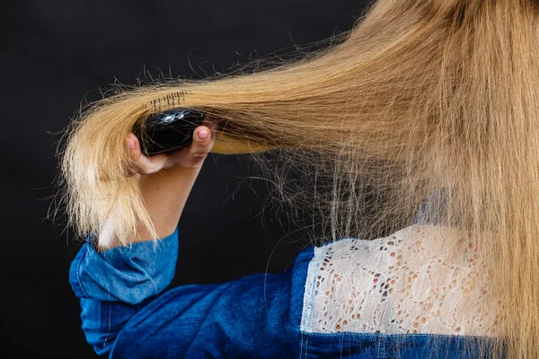 Blond kobieta czesanie jej włosy. — Zdjęcie stockowe