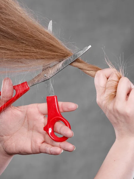 Mujer rubia cortándose el pelo . — Foto de Stock