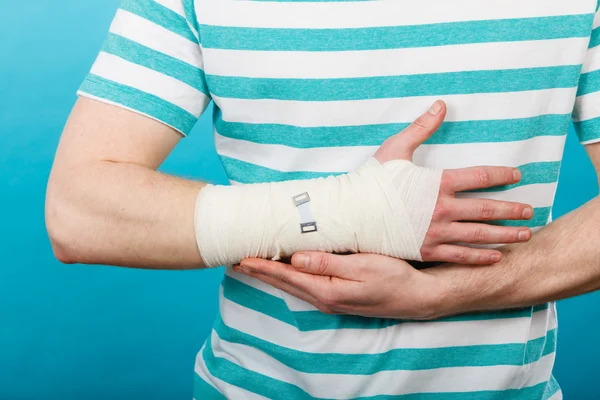 Man med smärtsamma bandagerade hand. — Stockfoto