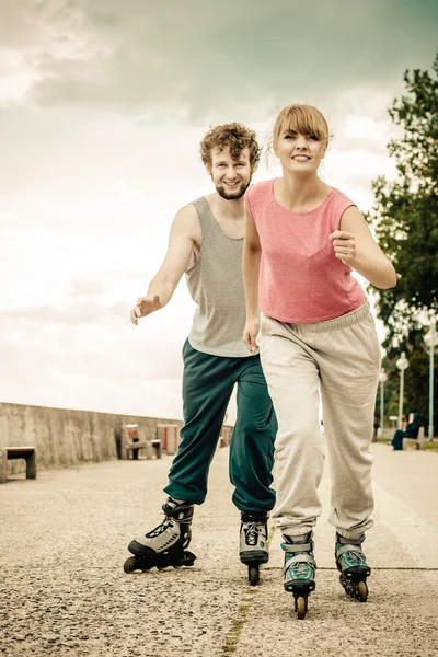 Dos personas corren juntas montando patines . — Foto de Stock