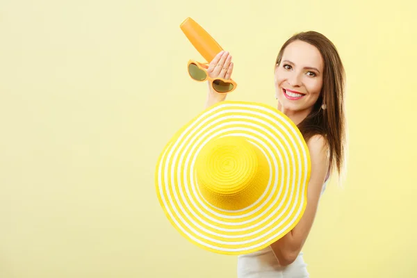 Женщина в летней шляпе держит солнцезащитный лосьон — стоковое фото