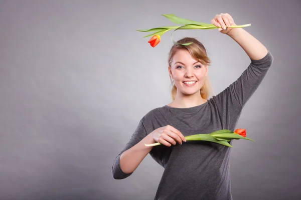 Hravá dívka se baví s květy tulipánů. — Stock fotografie