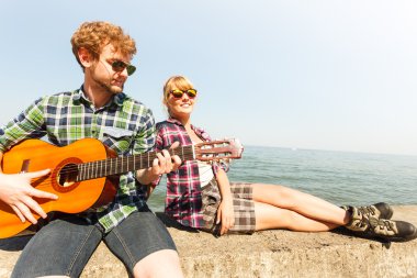 Genç kadın için gitar çalmak hipster adam.