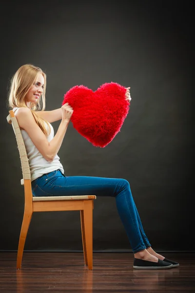 Mujer sosteniendo corazón en forma de almohada símbolo de amor — Foto de Stock