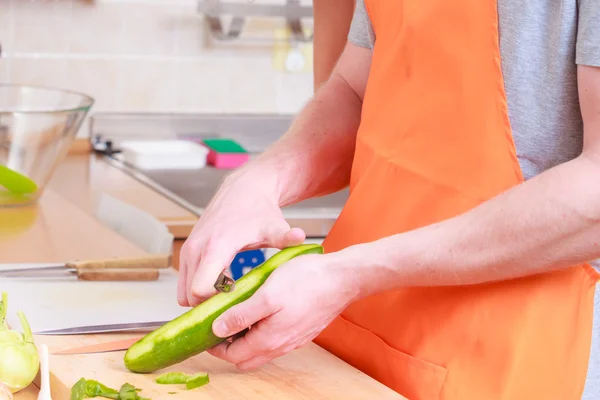 Hombre preparando verduras ensalada pelado pepino — Foto de Stock