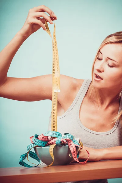 Dietu. Dívka s barevnými měřicí pásky v misce — Stock fotografie