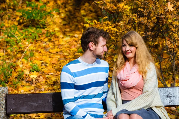 Älskande par i höst park på bänk — Stockfoto