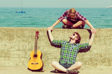Genç adam onun kız arkadaşı deniz kenarında gitar çalmak