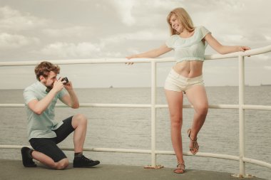 Aşık genç bir çift deniz iskelede fotoğraf çekmek.