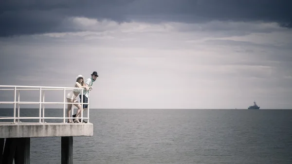 Kärleksfull hipster par på piren i havet — Stockfoto