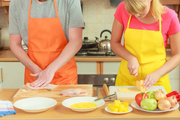 Man cutting meat on board. Couple in kitchen — Stock Photo, Image