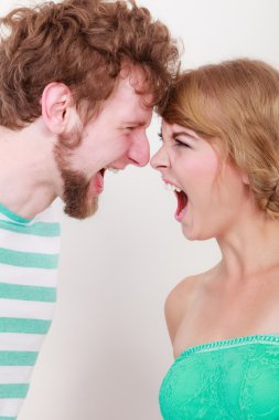 Öfkeli kadın ve erkek birbirlerine bağırıyorlar.