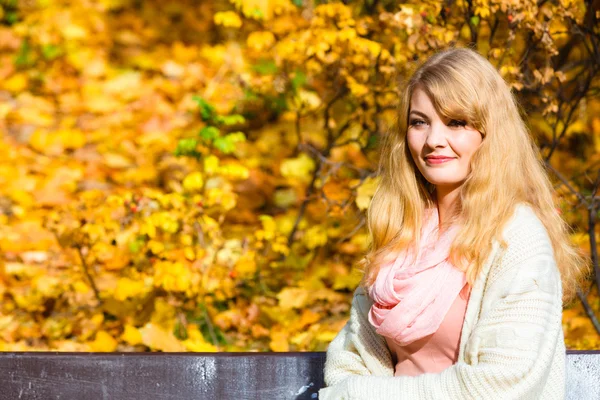 Kvinna sitter på bänk i parken — Stockfoto